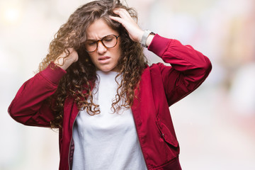 Canvas Print - Beautiful brunette curly hair young girl wearing jacket and glasses over isolated background with hand on head for pain in head because stress. Suffering migraine.