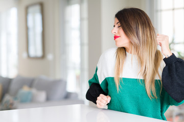 Canvas Print - Young beautiful woman wearing winter sweater at home stretching back, tired and relaxed, sleepy and yawning for early morning