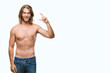 © Krakenimages.com - Young handsome shirtless man with long hair showing sexy body over isolated background smiling and confident gesturing with hand doing size sign with fingers while looking and the camera