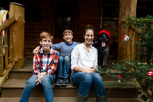 Three Kids And Their Dog Posing For Christmas Photos