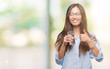 © Krakenimages.com - Young asian woman drinking a glass of water over isolated background happy with big smile doing ok sign, thumb up with fingers, excellent sign