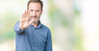 © Krakenimages.com - Handsome middle age elegant senior man over isolated background doing stop sing with palm of the hand. Warning expression with negative and serious gesture on the face.