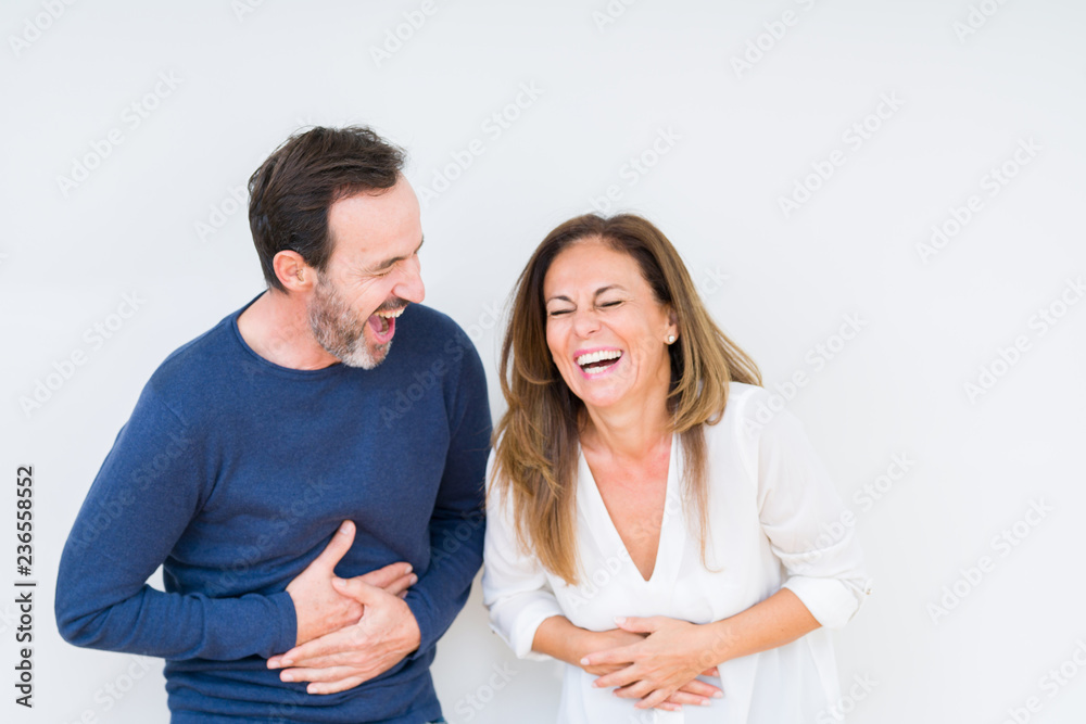 Beautiful middle age couple in love over isolated background Smiling and laughing hard out loud because funny crazy joke. Happy expression. - obrazy, fototapety, plakaty 