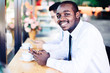 © arrowsmith2 - African business man playing smartphone in coffee shop with asian friends