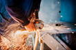© aboutmomentsimages - close up industrial workers hands cutting iron with angle grinder. Factory production details