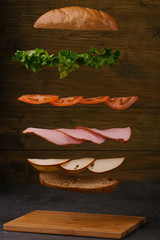 Wall Mural - levitating sandwich with ham, cheese, tomatoes and lettuce