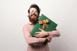 © Vulp - Smiling bearded man holding big gift box for christmas over white background