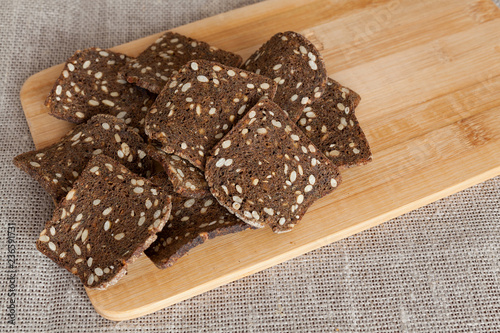 Fotografía Croutons of rye bread with seeds on a cutting board. Copy space.