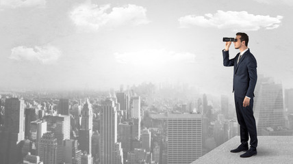 Wall Mural - businessman looking forward to a city with binoculars from skyscraper concept