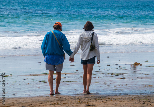 Fotografie, Obraz Senior citizen baby boomer male and female caucasian couple walking on the beach