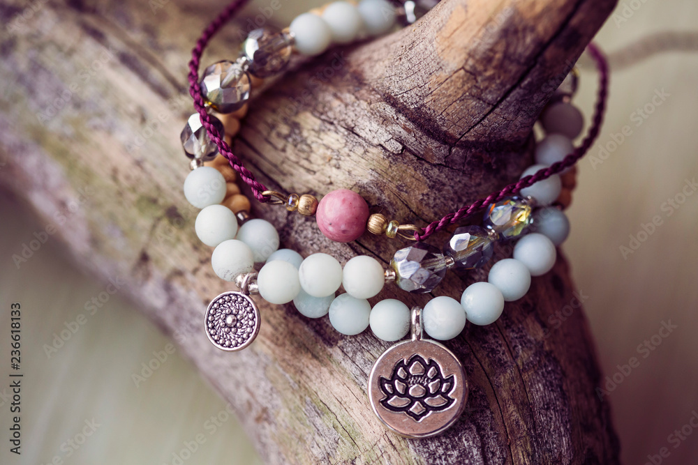 Three natural mineral stone beads bracelet on wooden background - obrazy, fototapety, plakaty 