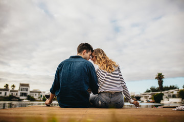 Wall Mural - Couple on a romantic date sitting near a lake