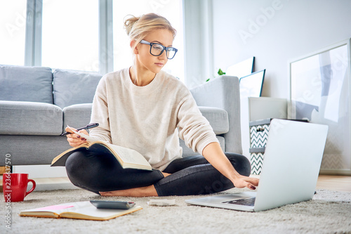 Fotomural Woman using laptop paying bills online and managing home budget