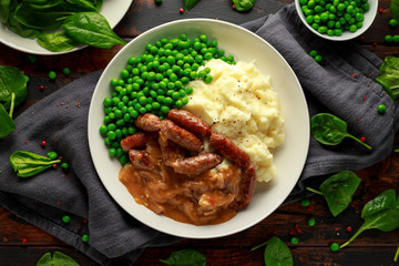 Mashed potatoes and sausages, bangers with onions gravy, green peas