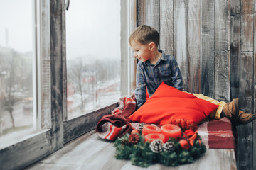 Boy sitting and looking at the window Waiting for Christmas