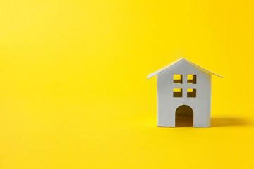 Simply design with miniature white toy house isolated on yellow colourful trendy modern fashion background. Mortgage property insurance dream home concept. Copy space