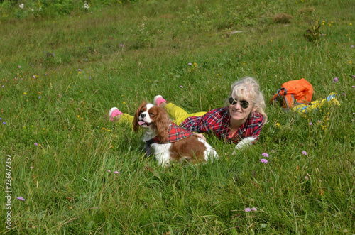 Fotografie, Obraz Woman dressed in rustic royal stewart shirt, lying on green meadow resting with