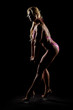 © Artenex - Athletic woman in pink bikini posing in studio. Attractive fitness lady with long blond hair showing her muscles