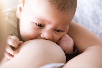 mother breastfeeding and hugging baby. young mom breast feeding her newborn child. lactation infant 