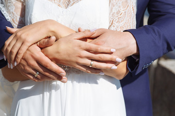 Wall Mural - newlyweds hold each other's hands with golden rings