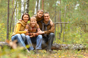 Poster - Portrait of family of four resting in autumn forest