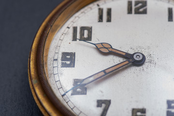 Old antique pocket watch on natural stone background.