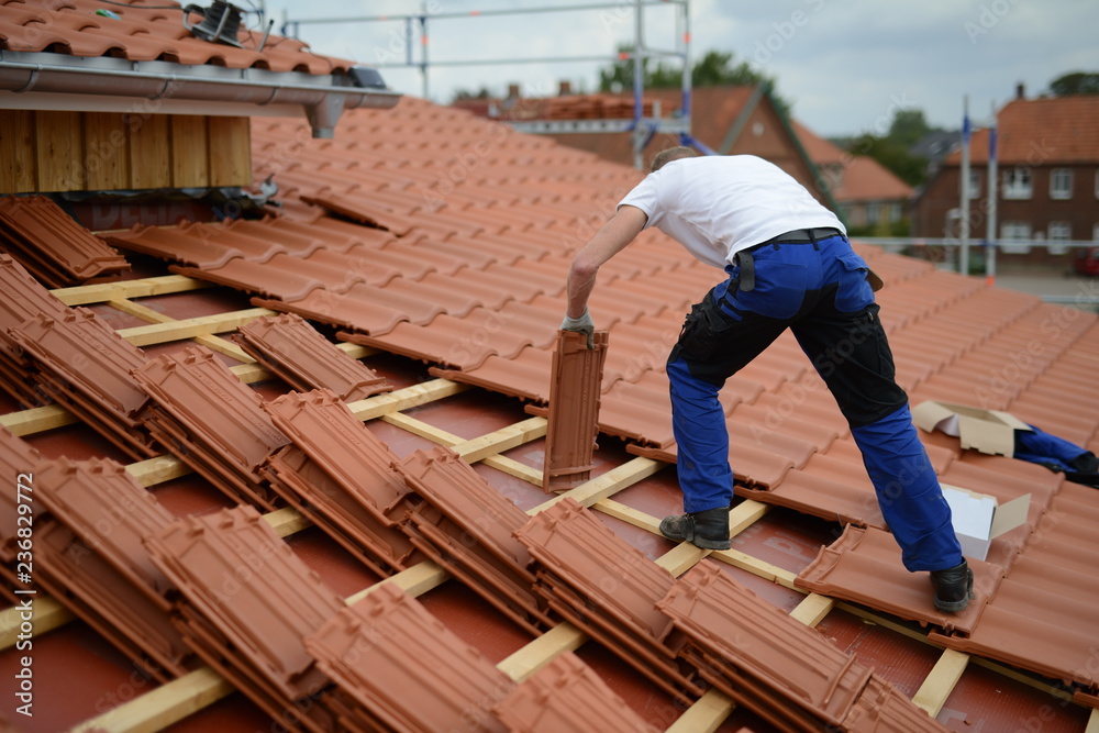 Dachdecker Bauarbeiter Mann auf Haus beim Ton Dachziegeln decken an der Arbeit - obrazy, fototapety, plakaty 