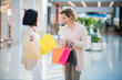 © romankosolapov - Two beautiful young women in a shopping center checking bags