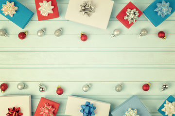  Christmas composition with place for text. Red, blue and white gift boxes with bows and small Christmas balls laid out on a light blue background.