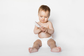 portrait of a smilling baby girl with hair brush isolated on a white background. pretty baby girl in