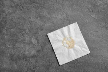 Wall Mural - Dirty napkin with coffee stain on grey background, top view. Space for text