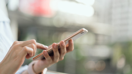 Wall Mural - woman using smartphone on staircase in public areas, During leisure time. The concept of using the phone is essential in everyday life.