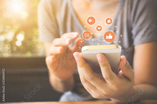 Fotomural Woman hand using mobile smartphone with icon social media and social network