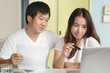 © Pormezz - Comfort e-commerce shopping, Asian couple shopping online and payment by credit card.