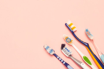 Wall Mural - Several different used toothbrushes on a pink background. Toothbrush change concept, oral hygiene, big and friendly family, toothbrush selection. Flat lay, top view