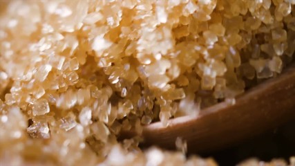 Poster - Slow motion closeup shot wooden spoon picking brown sugar in the bowl