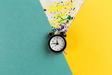 Wall Mural - Vintage alarm clock on a creative colorful background with paint sprinkles