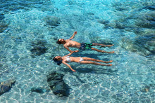Happy Couple Swimming In The Transparent Turquoise Sea