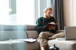 © Drobot Dean - Concentrated young bearded man sitting in home writing notes.