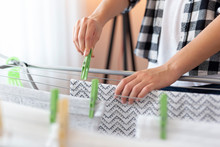 Woman Hanging Wet Clothes With Clothespins