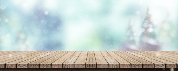 Poster - Wood table with abstract blur christmas tree and snow fall background with bokeh light.Mock up banner for display or montage of product.