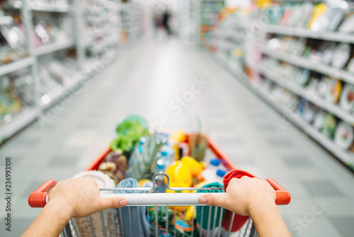 Cuadros en Lienzo Female person hands drags the cart full of goods