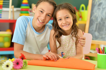 Canvas Print - Portrait of smiling brother and sister drawing together