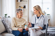 © Halfpoint - A health visitor explaining a senior woman how to take pills.