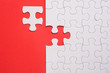 © azrisuratmin - Incomplete white jigsaw puzzle pieces on red background