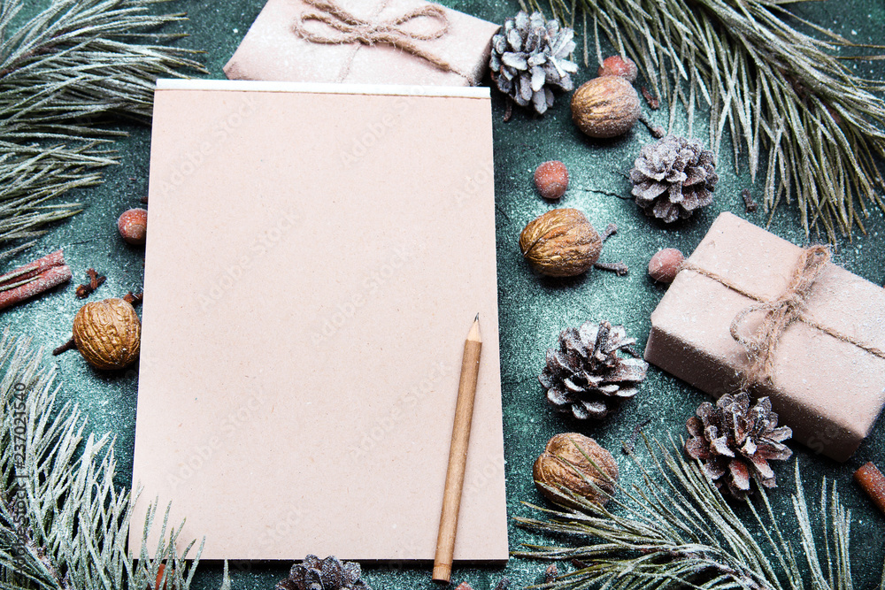 Tło na Boże Narodzenie  z pustą kartka papieru otoczoną świątecznymi dekoracjami. Miejsce na tekst. List do Mikołaja lub Świąteczna lista zakupów - obrazy, fototapety, plakaty 