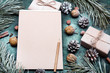 Tło na Boże Narodzenie  z pustą kartka papieru otoczoną świątecznymi dekoracjami. Miejsce na tekst. List do Mikołaja lub Świąteczna lista zakupów