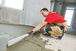 © Kadmy - Floor cement work. Plasterer smoothing floor surface with screeder