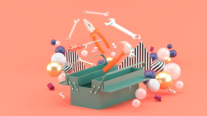 Toolbox amidst colorful balls on a pink background.-3d rendering.