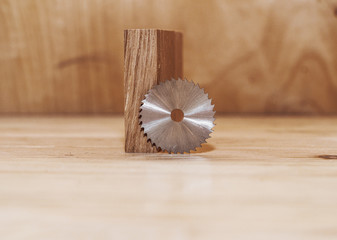 Sticker - Little circular saw on the background of wooden bars. Workshop. Manufacture of wooden products. Joiner's cutting tool